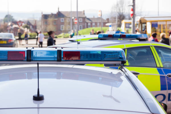 Police cars with sirens and pedestrians