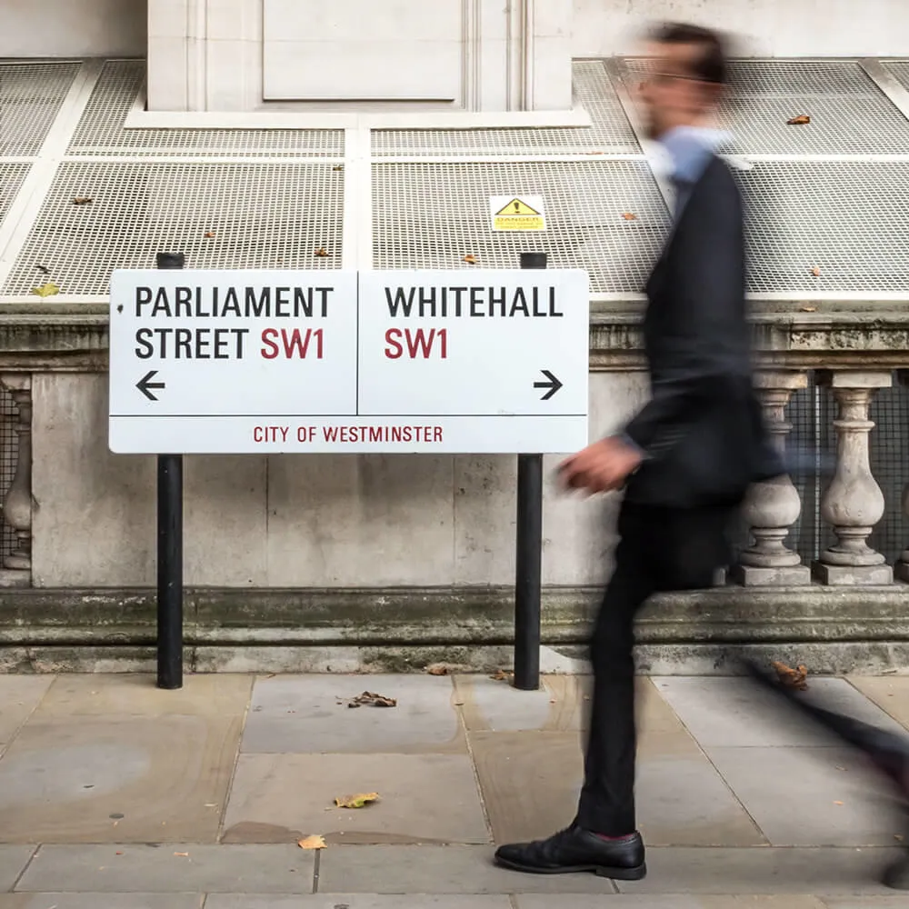 Man walking past City of Westminster sign